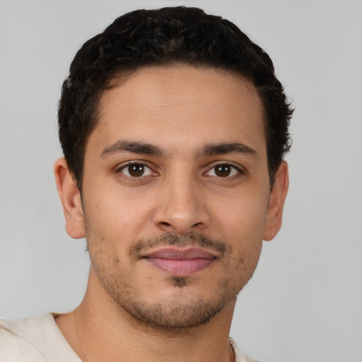 Joyful latino young-adult male with short  brown hair and brown eyes