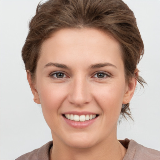 Joyful white young-adult female with short  brown hair and grey eyes