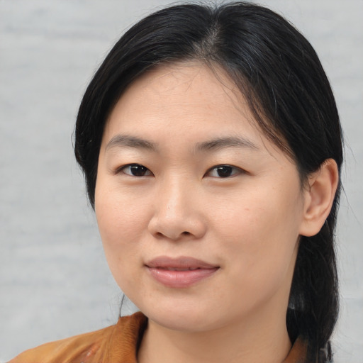 Joyful asian young-adult female with medium  brown hair and brown eyes