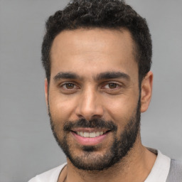 Joyful white young-adult male with short  black hair and brown eyes