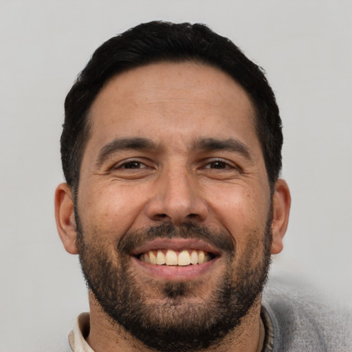 Joyful white adult male with short  black hair and brown eyes