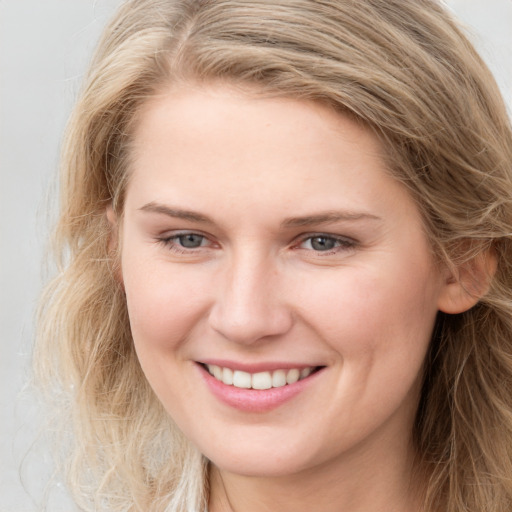 Joyful white young-adult female with long  brown hair and grey eyes