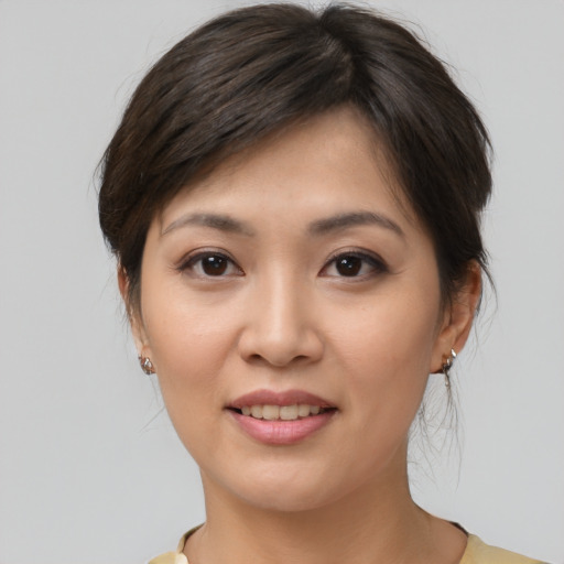 Joyful asian young-adult female with medium  brown hair and brown eyes