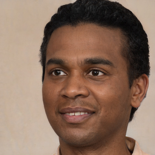 Joyful black young-adult male with short  black hair and brown eyes