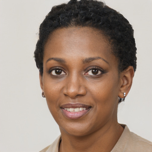Joyful black young-adult female with short  black hair and brown eyes