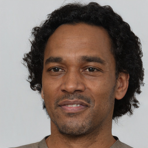 Joyful black adult male with short  black hair and brown eyes