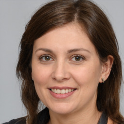 Joyful white adult female with medium  brown hair and brown eyes