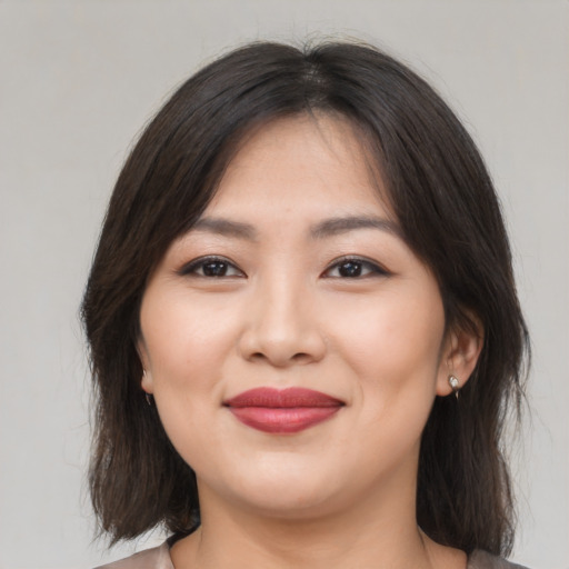 Joyful asian young-adult female with medium  brown hair and brown eyes