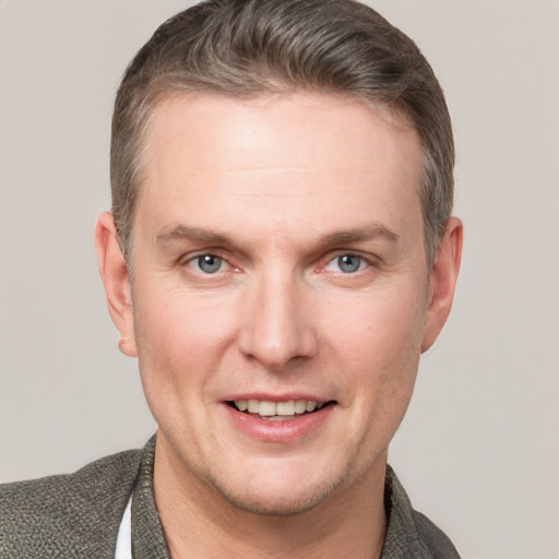 Joyful white adult male with short  brown hair and grey eyes