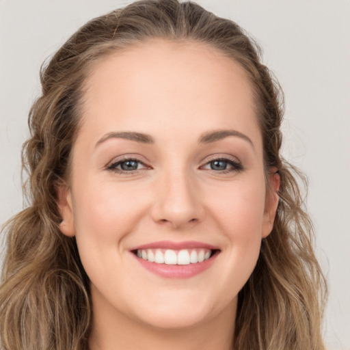 Joyful white young-adult female with long  brown hair and grey eyes