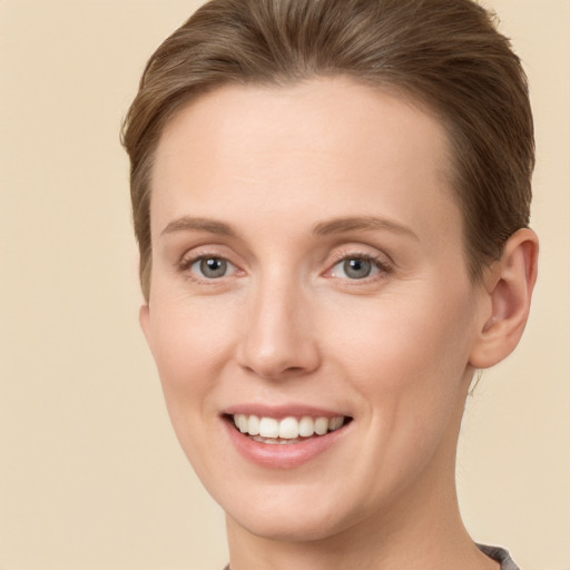 Joyful white young-adult female with short  brown hair and grey eyes