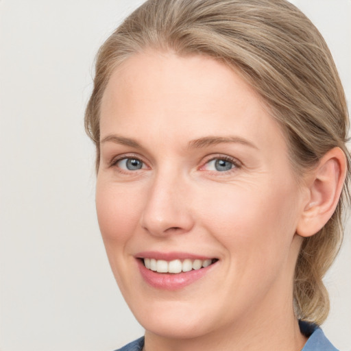 Joyful white young-adult female with medium  brown hair and blue eyes