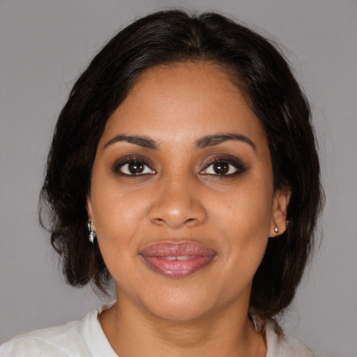 Joyful black young-adult female with medium  brown hair and brown eyes