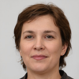 Joyful white adult female with medium  brown hair and grey eyes