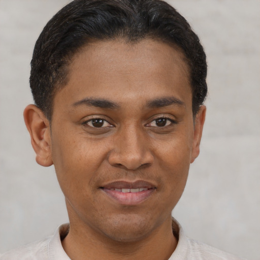 Joyful latino young-adult male with short  brown hair and brown eyes