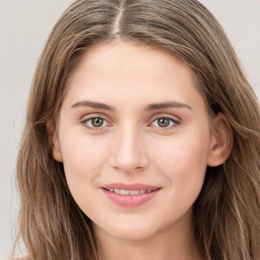 Joyful white young-adult female with long  brown hair and grey eyes