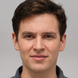 Joyful white young-adult male with short  brown hair and grey eyes