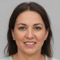 Joyful white adult female with medium  brown hair and brown eyes