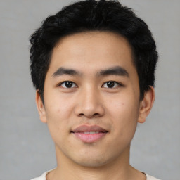 Joyful asian young-adult male with short  black hair and brown eyes