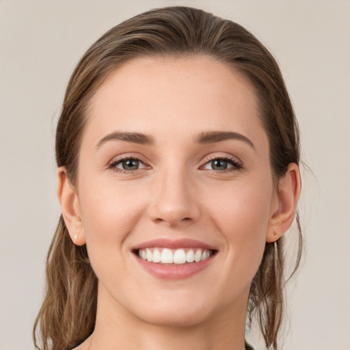 Joyful white young-adult female with medium  brown hair and grey eyes