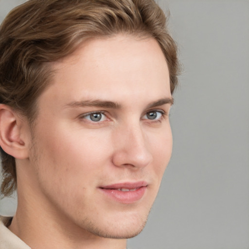 Joyful white young-adult male with short  brown hair and blue eyes