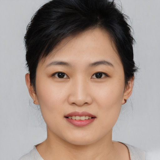 Joyful asian young-adult female with short  brown hair and brown eyes