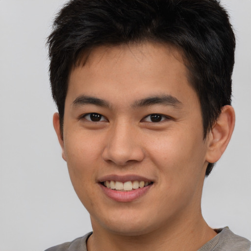 Joyful asian young-adult male with short  brown hair and brown eyes