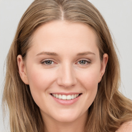 Joyful white young-adult female with long  brown hair and blue eyes