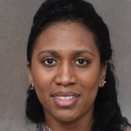 Joyful black adult female with long  black hair and brown eyes