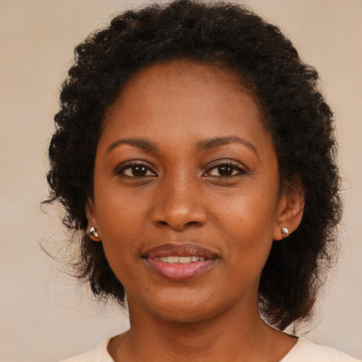 Joyful black young-adult female with medium  brown hair and brown eyes