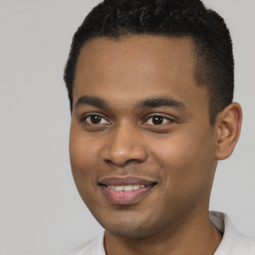 Joyful black young-adult male with short  black hair and brown eyes