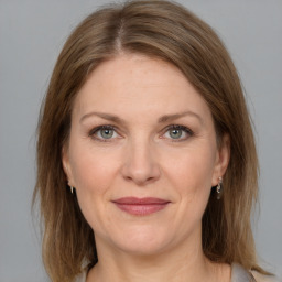 Joyful white adult female with medium  brown hair and grey eyes