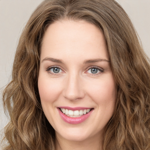 Joyful white young-adult female with long  brown hair and green eyes