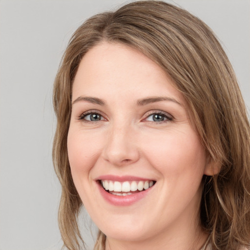 Joyful white young-adult female with medium  brown hair and green eyes