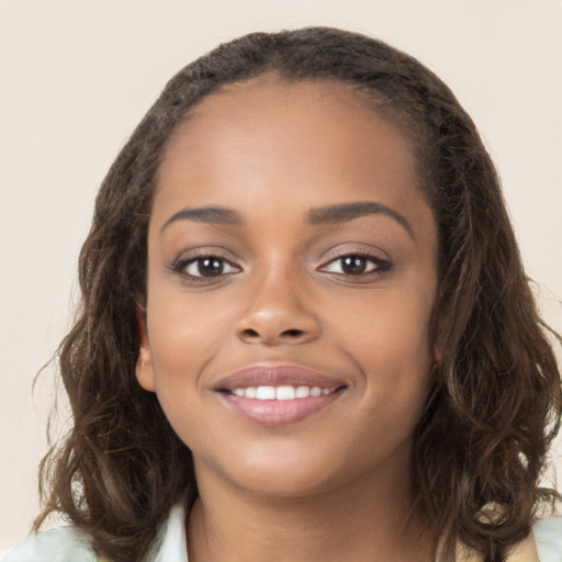 Joyful black young-adult female with long  brown hair and brown eyes