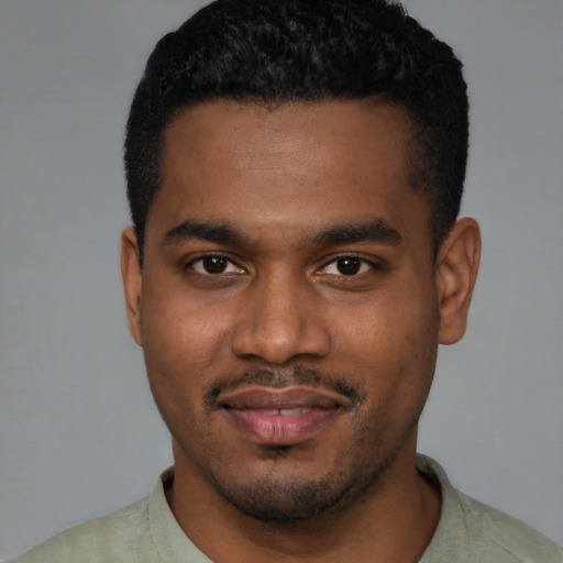 Joyful black young-adult male with short  black hair and brown eyes