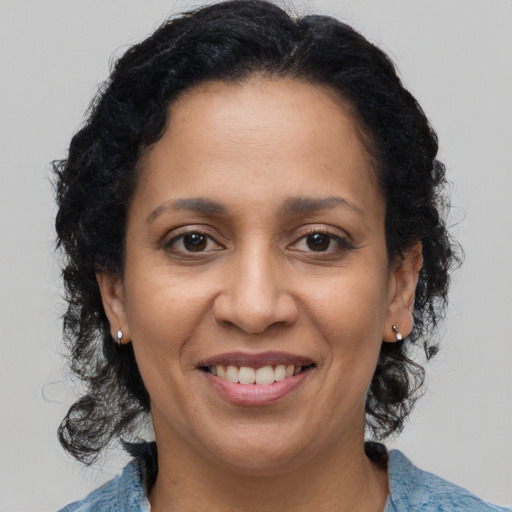 Joyful latino adult female with medium  brown hair and brown eyes