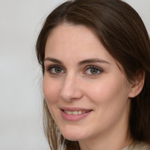 Joyful white young-adult female with medium  brown hair and green eyes