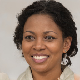 Joyful black adult female with medium  brown hair and brown eyes