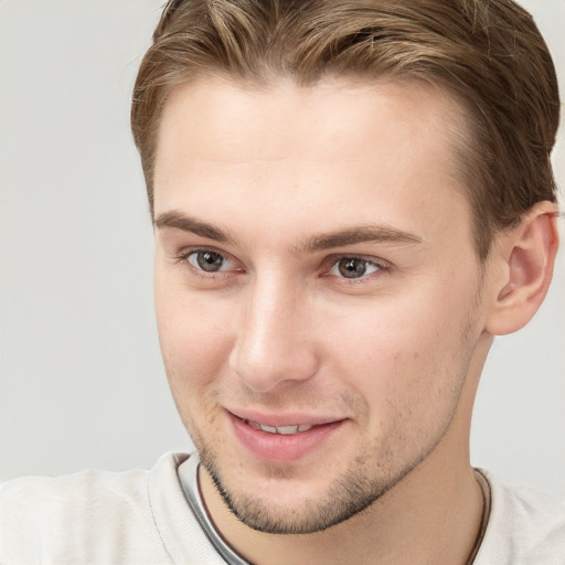 Joyful white young-adult male with short  brown hair and grey eyes