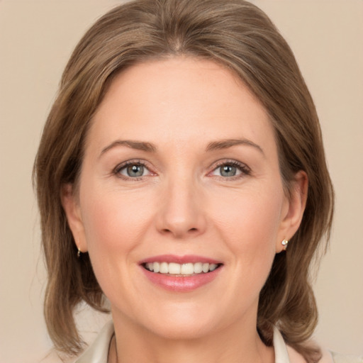 Joyful white young-adult female with medium  brown hair and green eyes