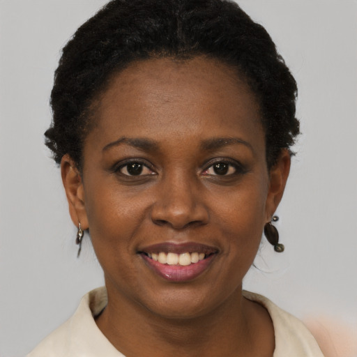 Joyful black young-adult female with short  black hair and brown eyes