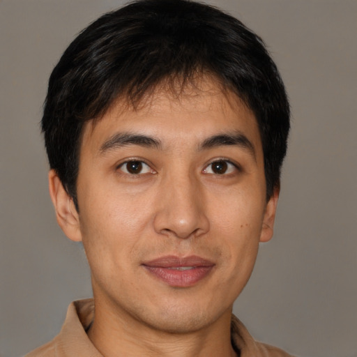 Joyful latino young-adult male with short  brown hair and brown eyes