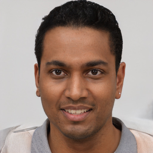 Joyful black young-adult male with short  black hair and brown eyes