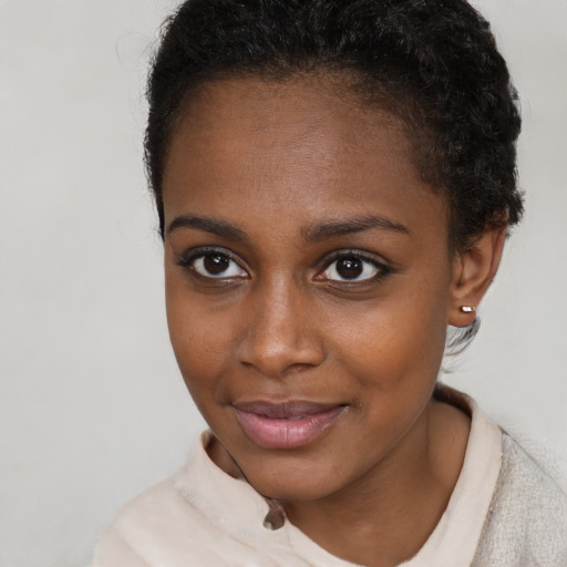 Joyful black young-adult female with short  brown hair and brown eyes