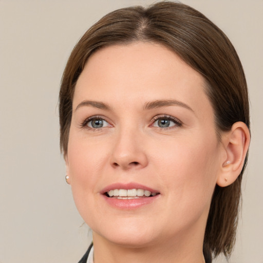 Joyful white young-adult female with medium  brown hair and grey eyes