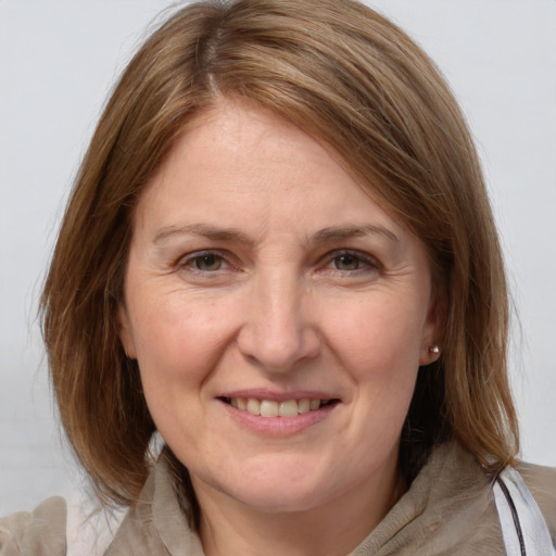 Joyful white adult female with medium  brown hair and grey eyes