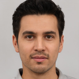 Joyful white young-adult male with short  black hair and brown eyes