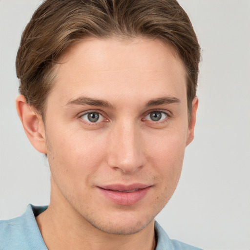 Joyful white young-adult male with short  brown hair and grey eyes