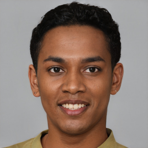Joyful black young-adult male with short  black hair and brown eyes